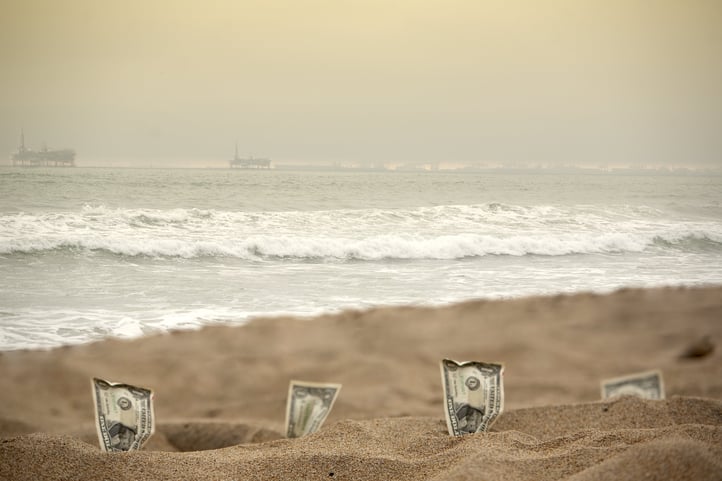 Idel cash, dollar bills laying on the beach